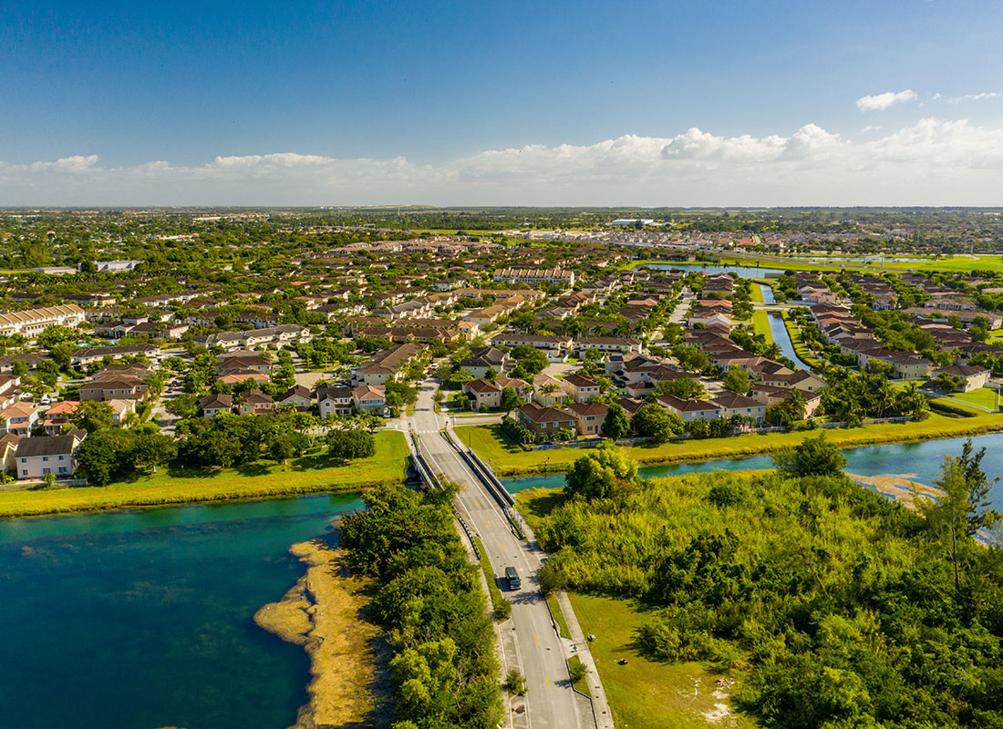 Flagami, FL - Aerial View of Homes Surrounded by Green Foliage Next to the Water in Flagami Florida on a Sunny Day