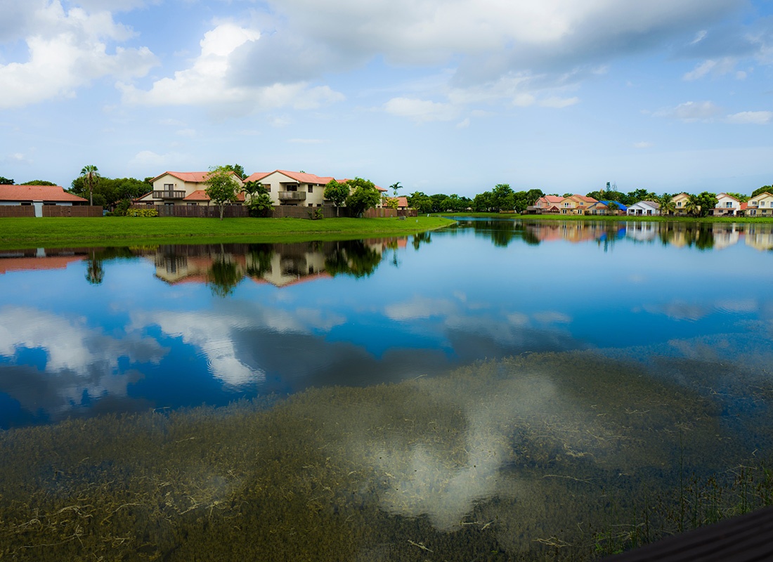 Kendall Lakes, FL - Scenic View of Homes by the Lake in Kendall Lakes Florida on a Sunny Day