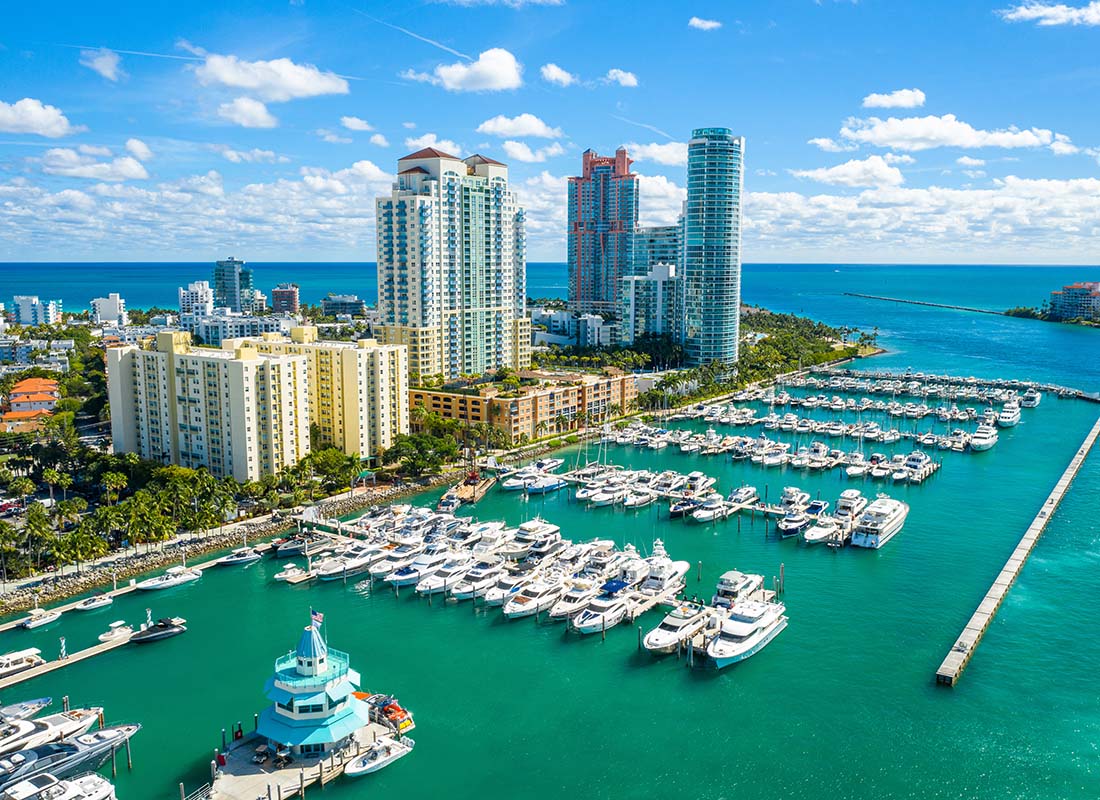 South Miami, FL - Aerial View of Modern Commercial Buildings Next to the Turquoise Water with Rows of Boats on Docks in South Miami Florida