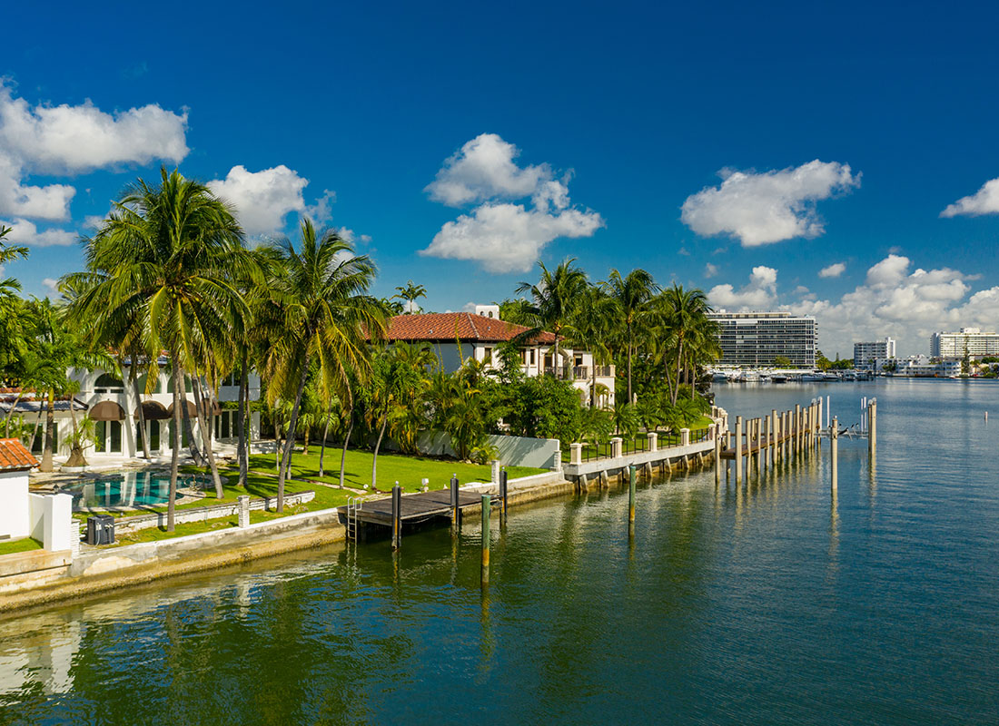 West Hialeah, FL - View of Luxury Homes by the the Water Next to Palm Trees on a Sunny Day in West Hialeah Florida