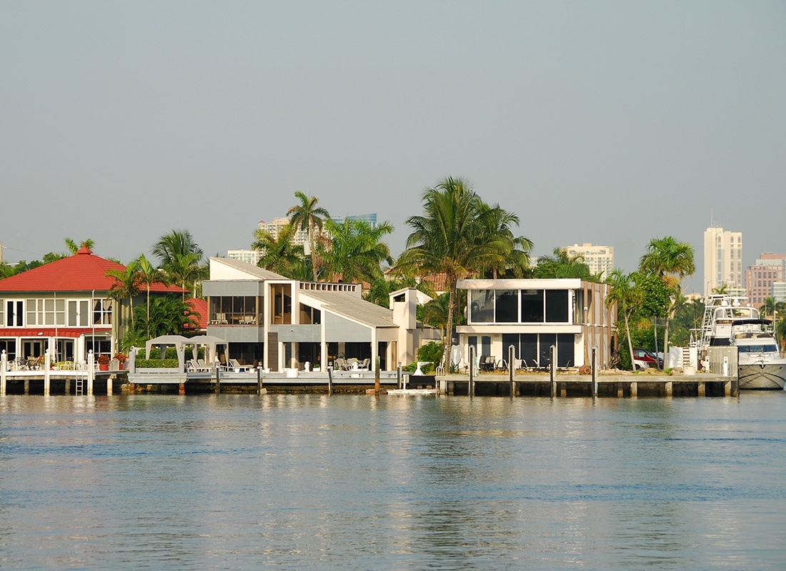 Westchester, FL - View of Multi Story Homes by the Water with Private Boat Docks Against a Grey Sky in Westchester Florida
